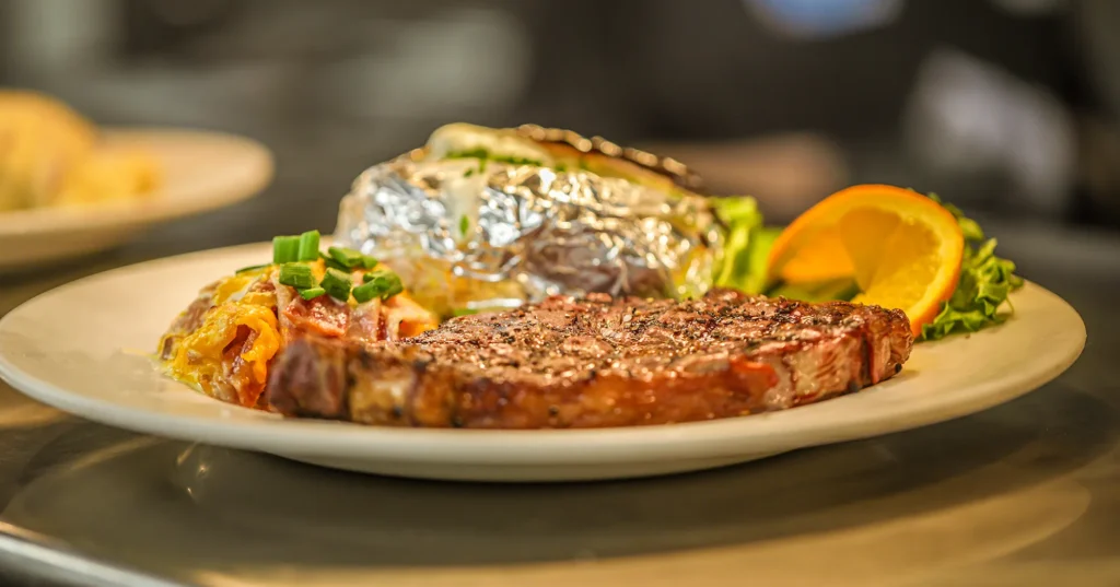 Steak and baked potato on plate